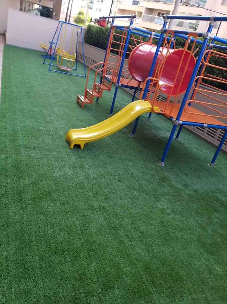 Playground com grama sintética.